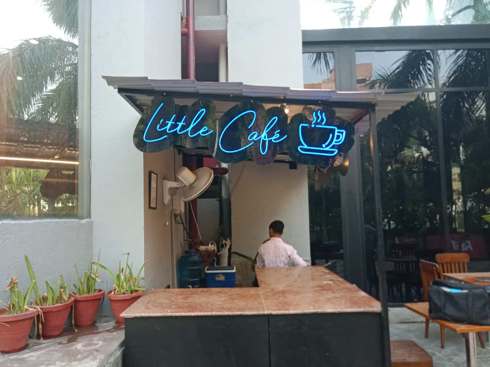 LED sign reading "Little Cafe" with a steaming coffee cup icon.